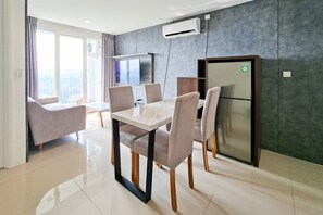A modern dining area with a marble table and chairs, a built-in air conditioning unit, and a view of the outdoors. - Bright And Convenient 2Br At Apartment Tuscany Residence (Tangerang)