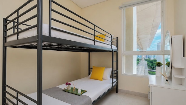 A bunk bed room with a window, a desk, and a mirror. - Bright Minimalist 2Br At Apartment Elpis Residence (Jakarta)