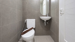 Ein Badezimmer mit Toilette, Waschbecken und Spiegel.