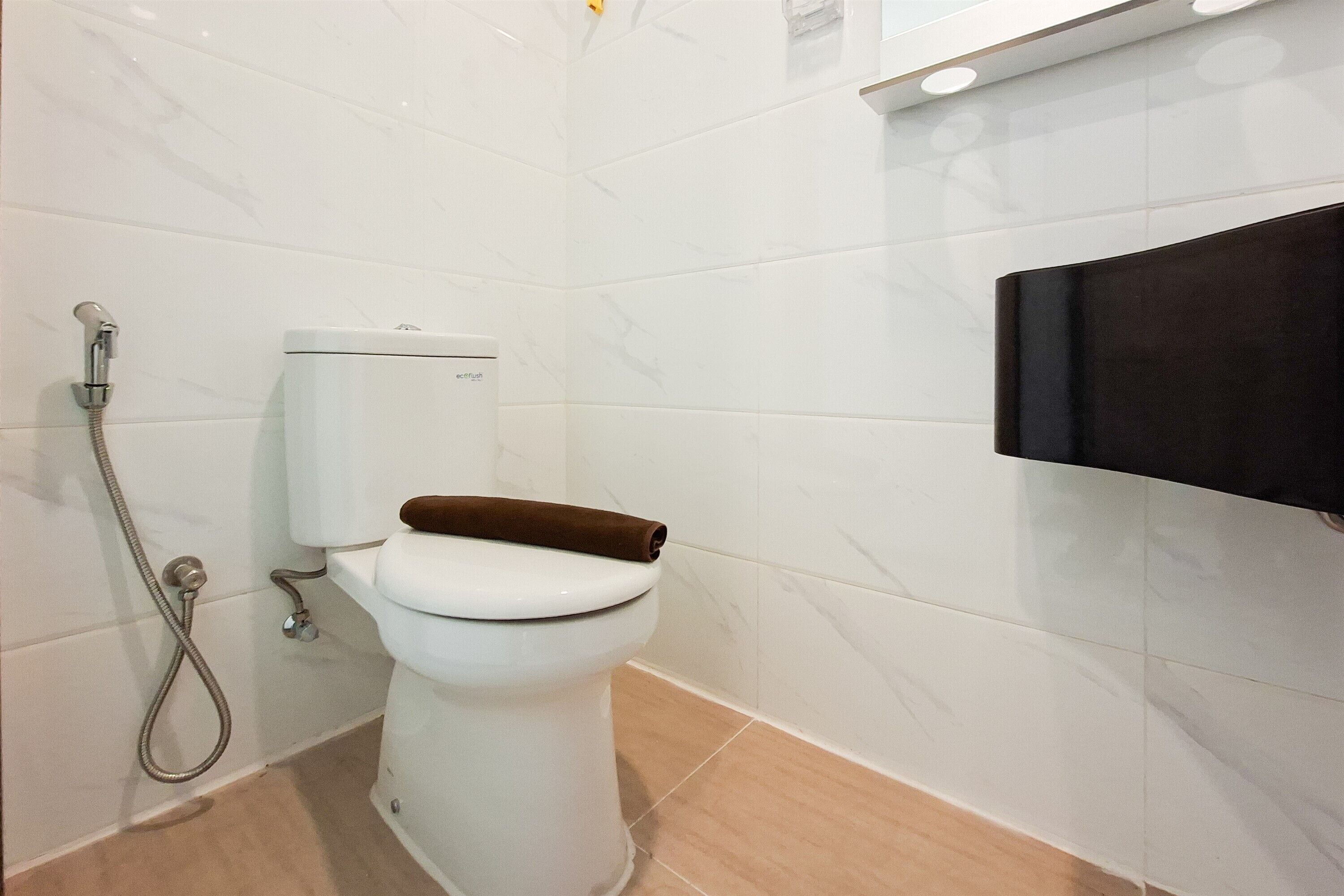 Ein Badezimmer mit Toilette, Dusche und einem schwarzen Schrank.