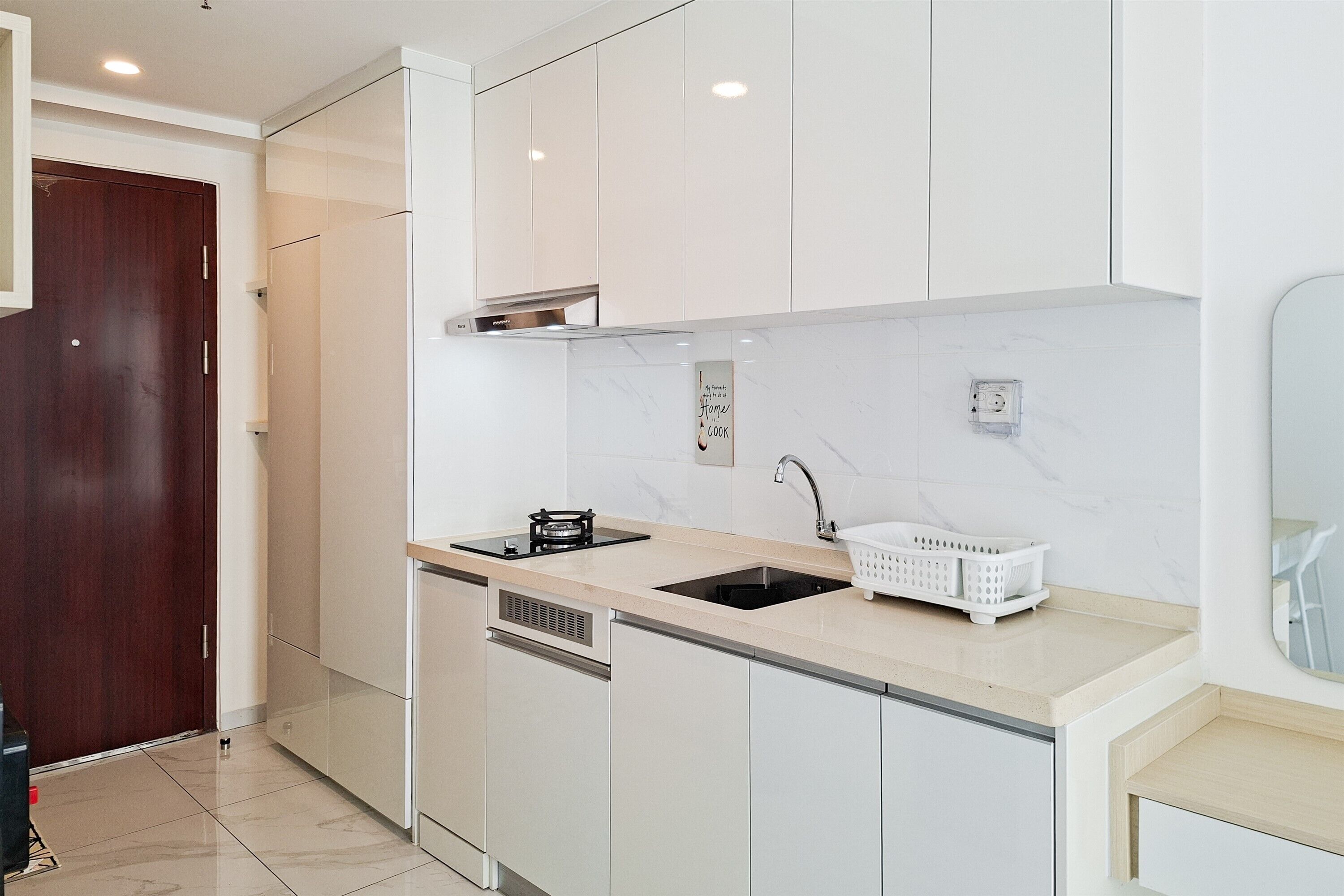 Una cocina moderna con armarios blancos, un lavaplatos de acero inoxidable y lavavajillas integrado.