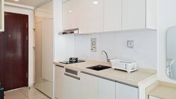 Una cocina moderna con armarios blancos, un lavaplatos de acero inoxidable y lavavajillas integrado.