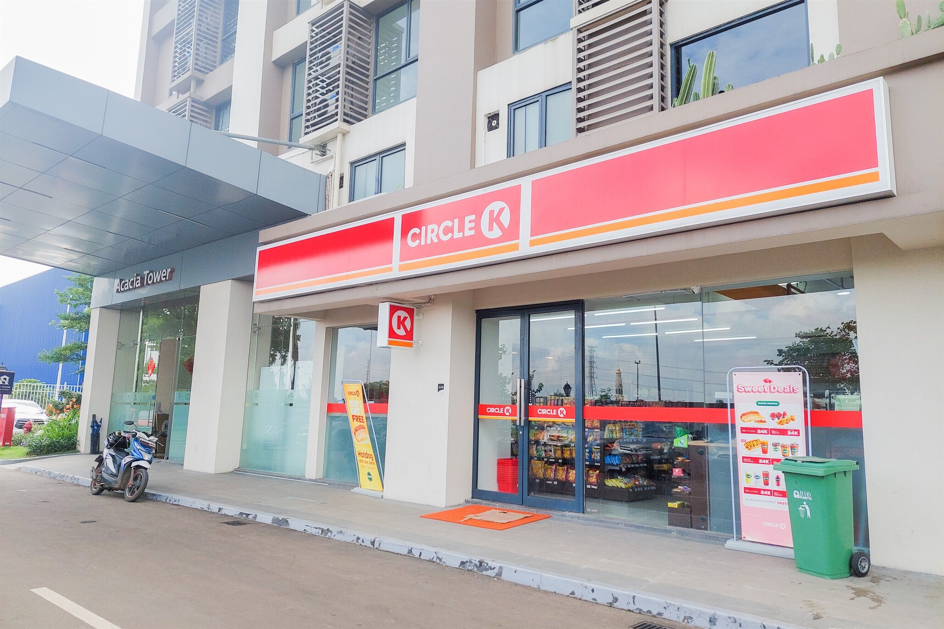 Een Circle K gemakswinkel met een duidelijke ingang en een motorfiets ervoor geparkeerd.