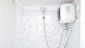 Suihkussa on käsisuihkupää ja seinään asennettu ohjauspaneeli.