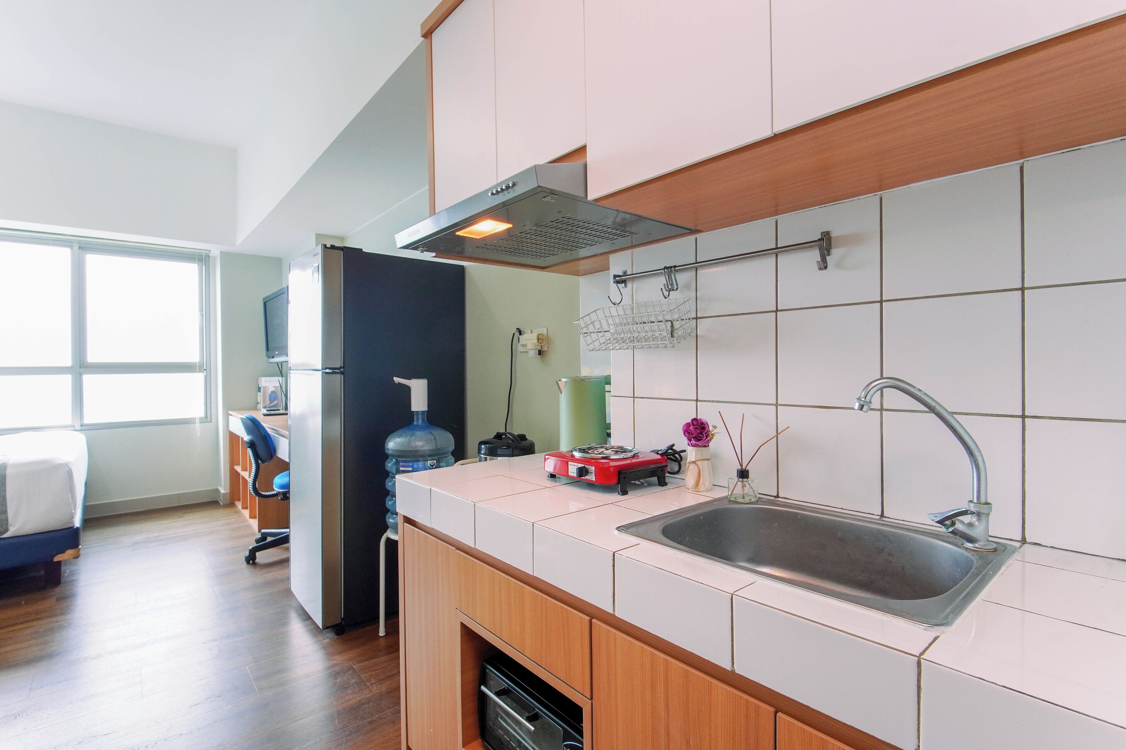 Una cucina moderna con forno integrato, lavello in acciaio inossidabile e una finestra che permette luce naturale.
