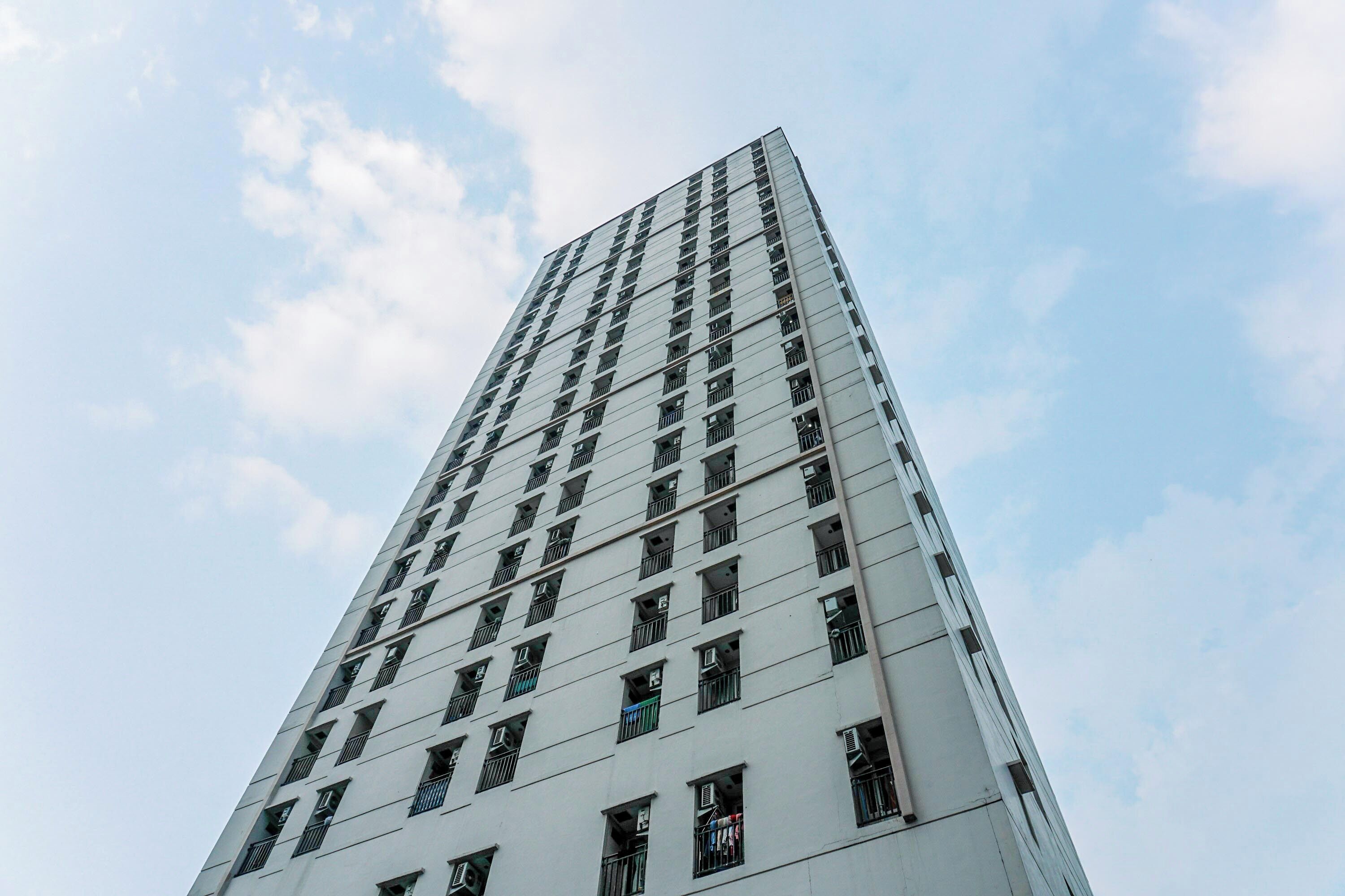 Um edifício alto e moderno, com uma fachada em grade de janelas e varandas.