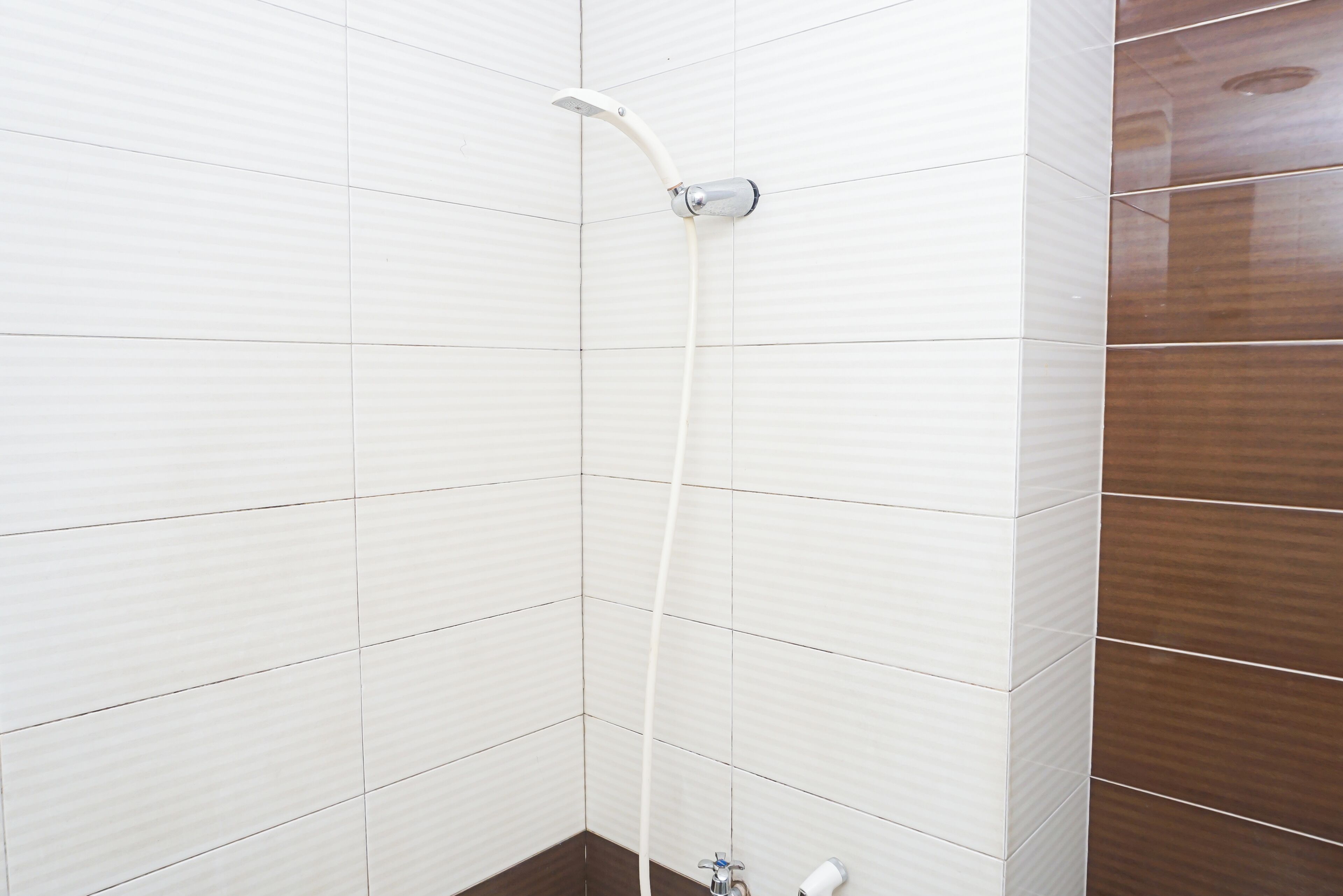 Eine Dusche mit Duschkopf und Wandarmatur.