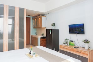 Una cocina moderna con horno integrado, refrigerador y comedor con mesa y sillas.