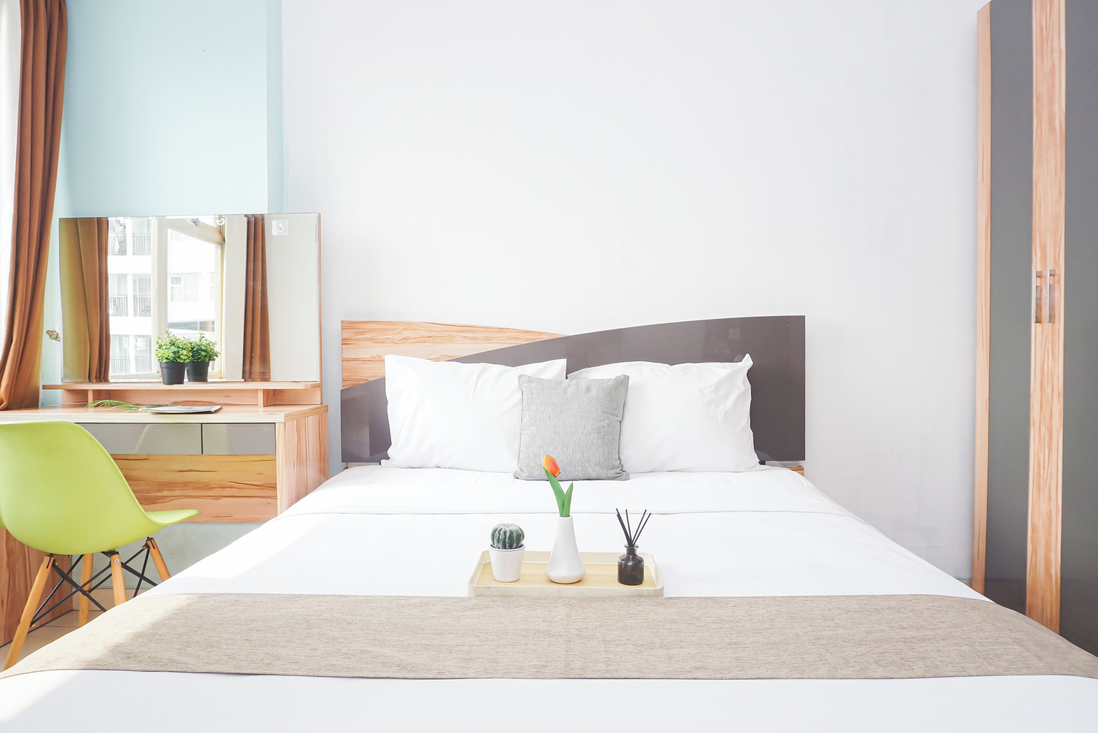 Una moderna camera d'hotel con un letto, un comodino e una scrivania con una sedia.