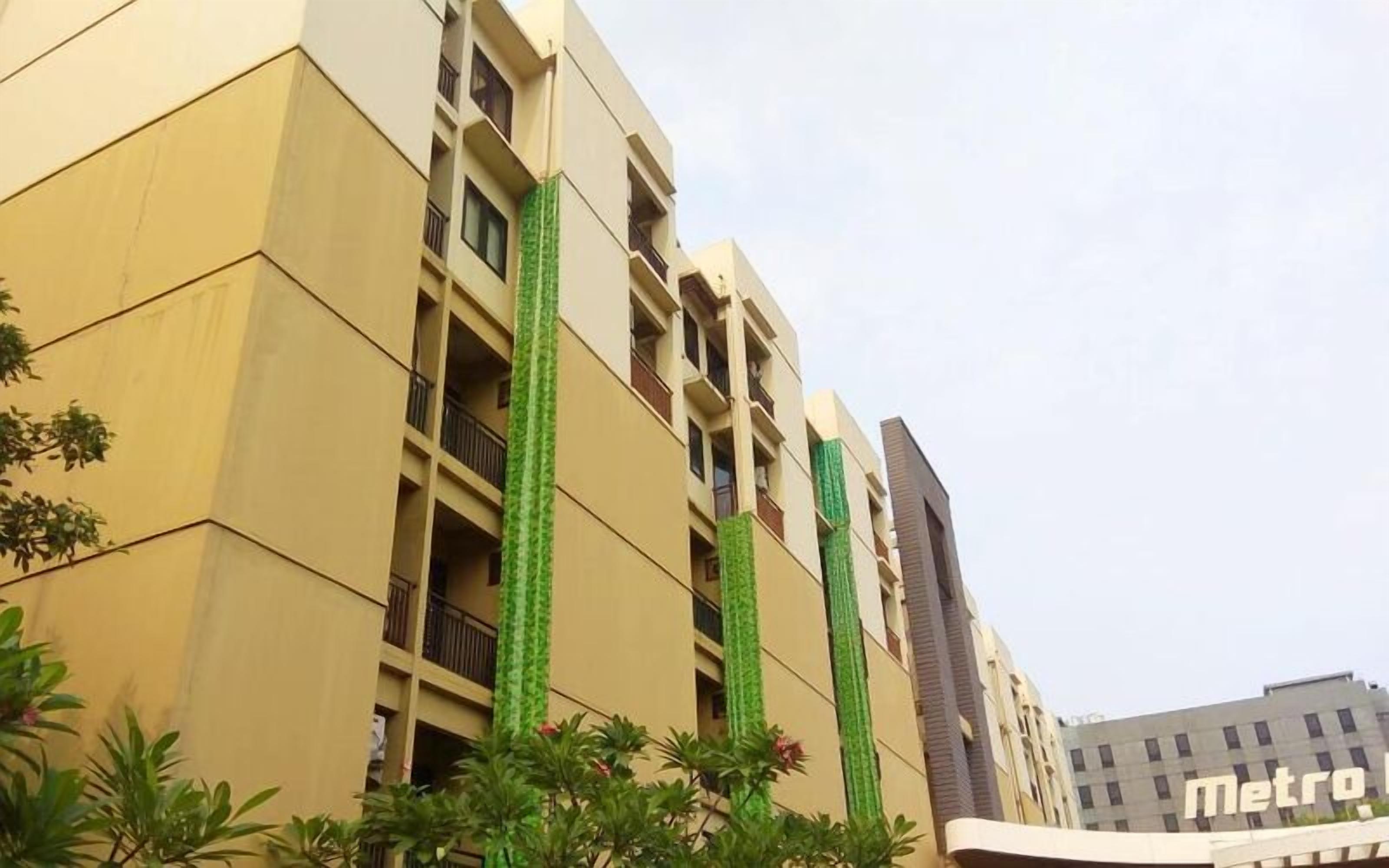 A multi-story building with balconies and a visible 'metro' sign, suggesting proximity to a metro station.