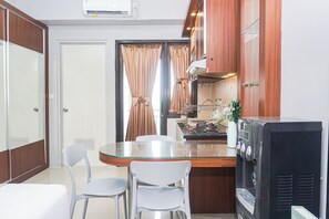 Eine kompakte Küche mit Essbereich, einem Kühlschrank und einem Fernseher.