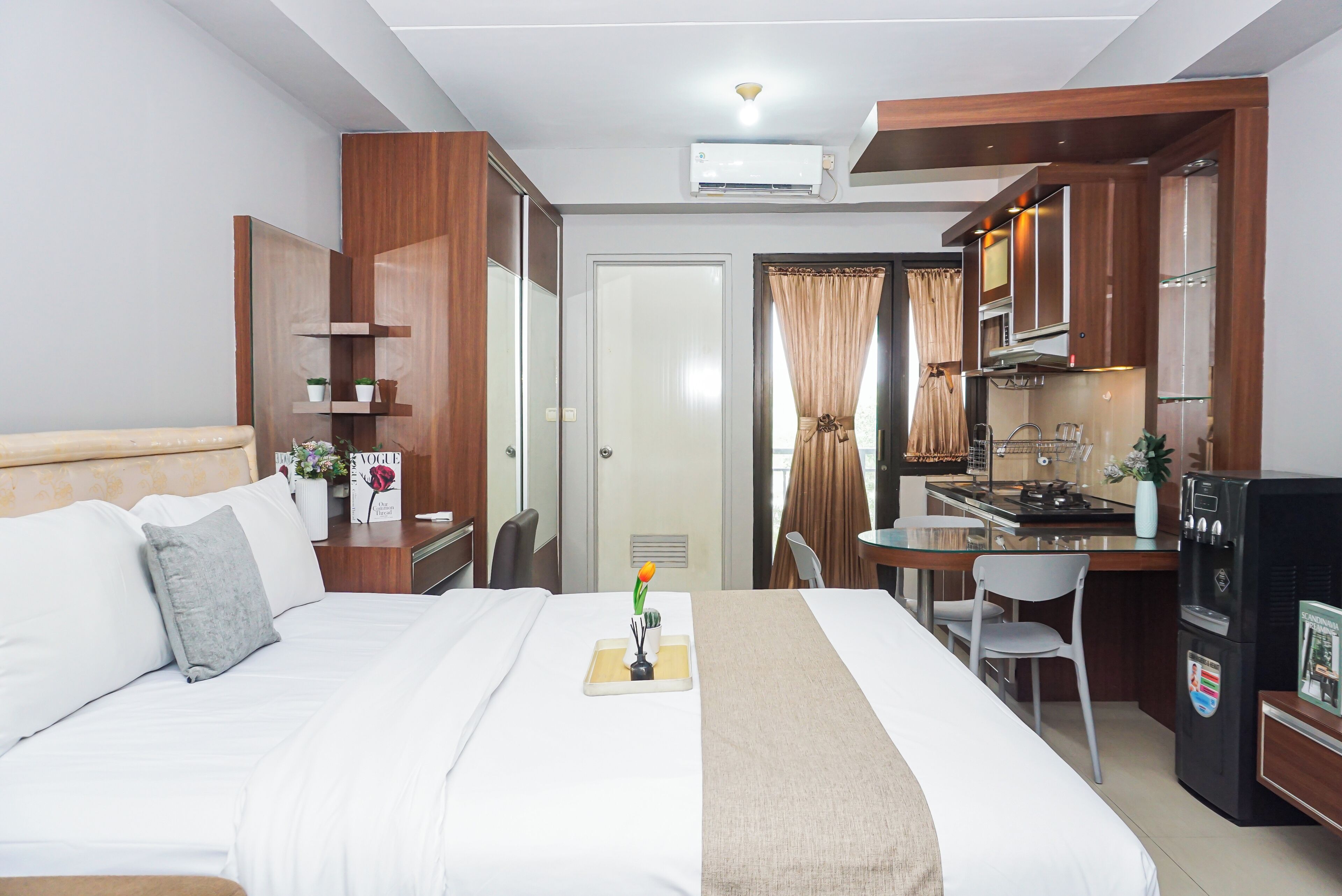 Ein Hotelzimmer mit einem Bett, einem Schreibtisch, einer Küchenzeile und einem Badezimmer.