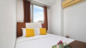 Ein Hotelzimmer mit einem Bett, braunen Vorhängen, einem Fenster und einem Tablett mit einer Vase und einer Kerze.