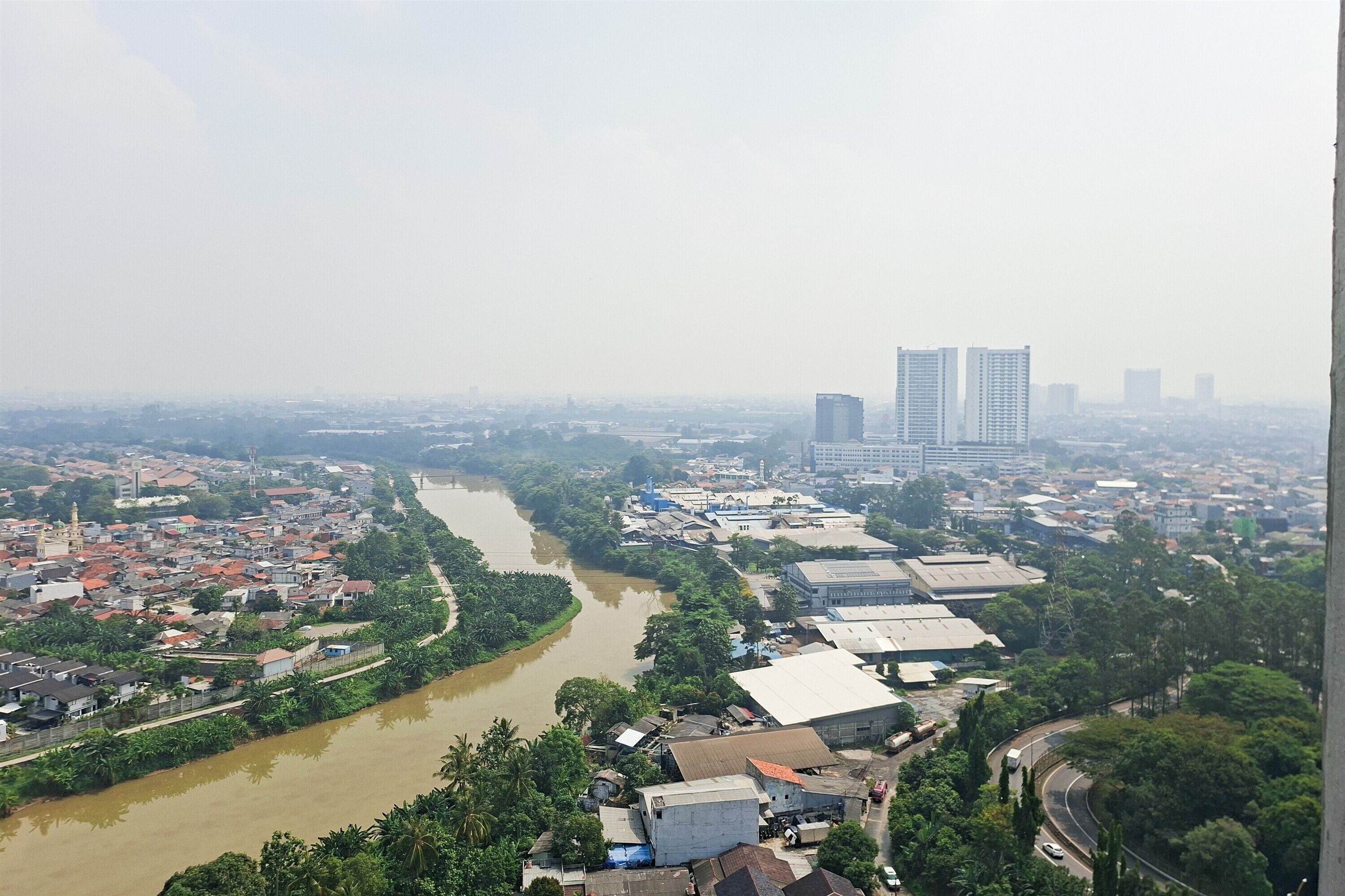 A river running through a city with buildings and greenery.