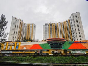 Un edificio de varios pisos con un cartel llamativo para "Great Western" y "Grand Serpong Mall" en la fachada.