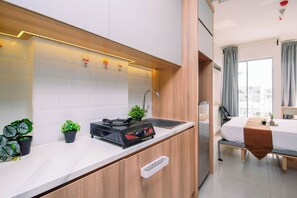 Una cuina moderna amb fornet integrat, un rentamics i una petita planta en test.