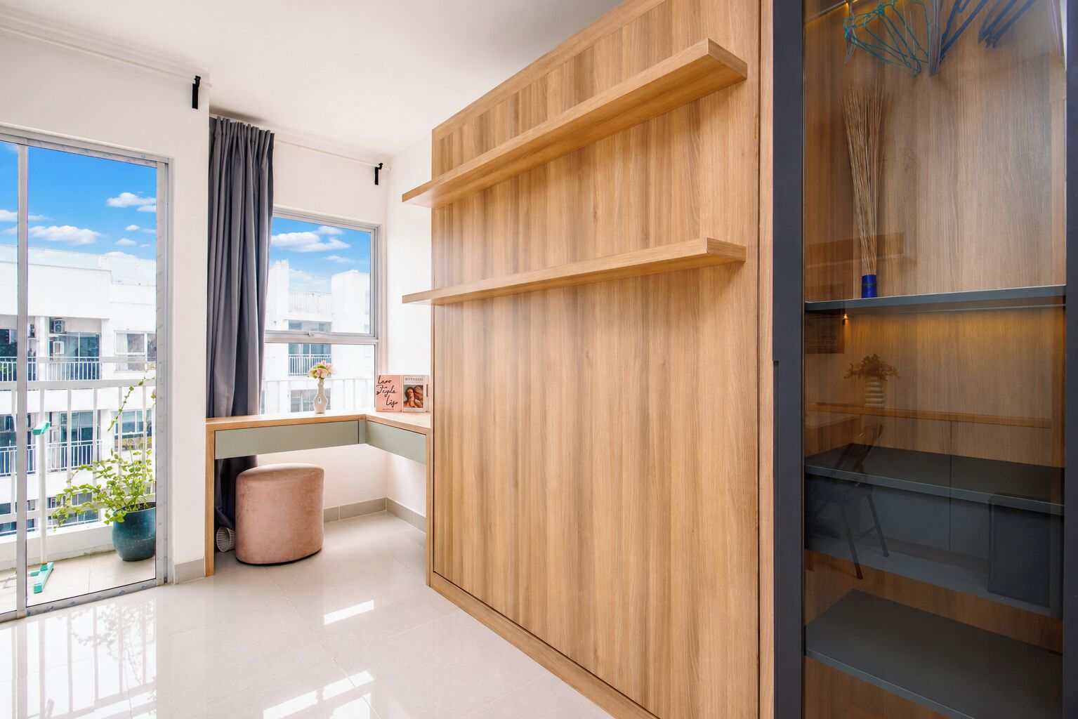 A modern room with a large window, a wooden cabinet, and a glass table.