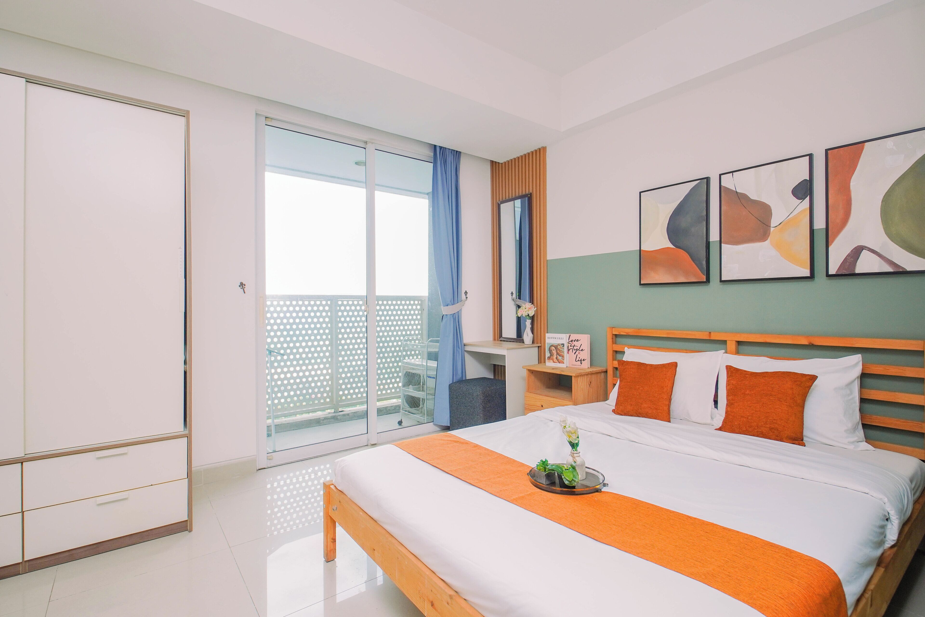 Ein Hotelzimmer mit Bett, Nachttisch, Spiegel und Bildern an der Wand.