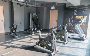Ein Fitnessstudio mit Trainingsgeräten, darunter Laufbänder und Kraftgeräte.