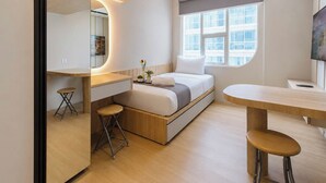 A compact bedroom with a bed, bedside table, and a small stool. - Stylish And Warm Studio At Apartment The City Square Surabaya (Surabaya)