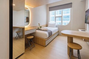 Ein gemütliches Schlafzimmer mit Bett, Nachttisch und einem kleinen Hocker.