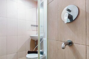 Ein Badezimmer mit Toilette, Waschbecken und einem Spiegel mit rundem Rahmen.