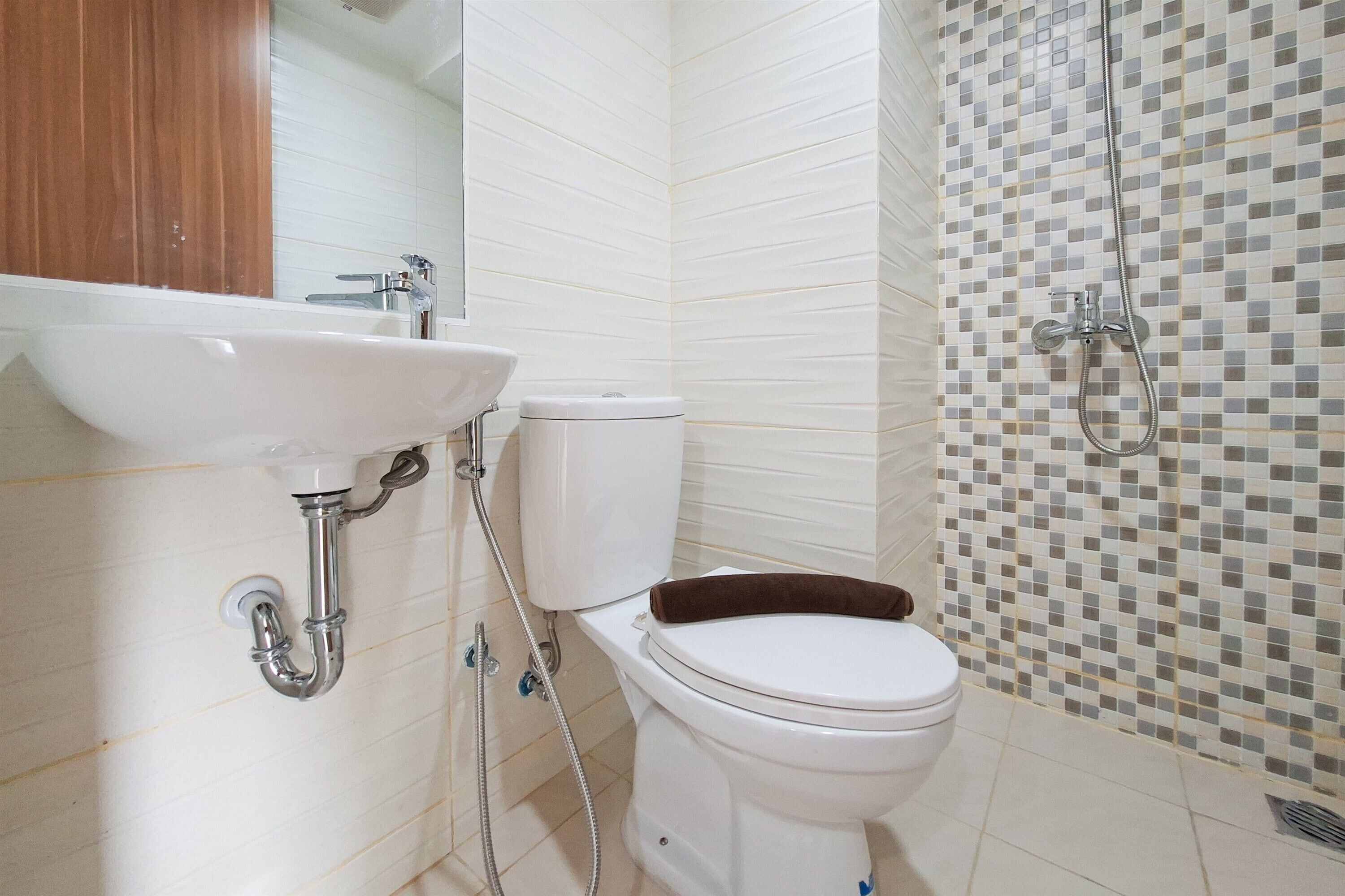 A bathroom with a white sink, toilet, and shower.