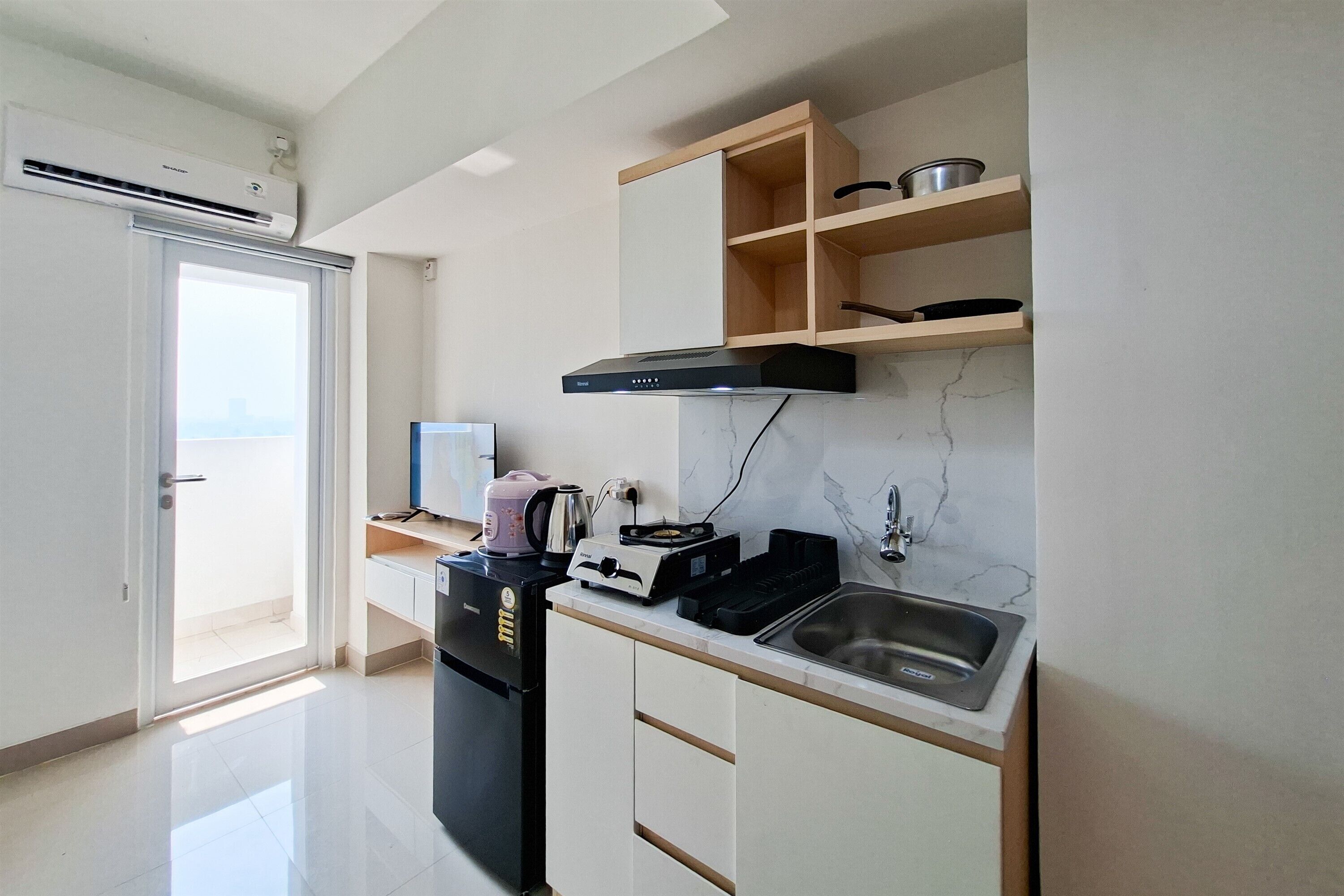 A compact kitchen with a built-in oven, a sink, and a microwave.