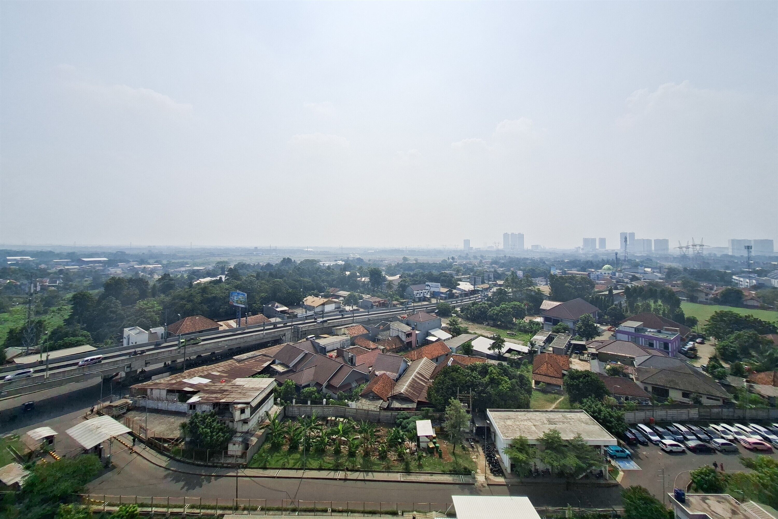 A residential area with houses, a highway, and distant buildings.