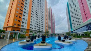 Una piscina con diseño circular, rodeada de edificios altos con balcones.