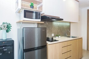 Una cocina moderna con refrigerador de acero inoxidable, microondas y estufa a gas.