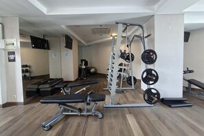 Ein Fitnessraum mit Gewichte, Trainingsmatten und einer Bank.