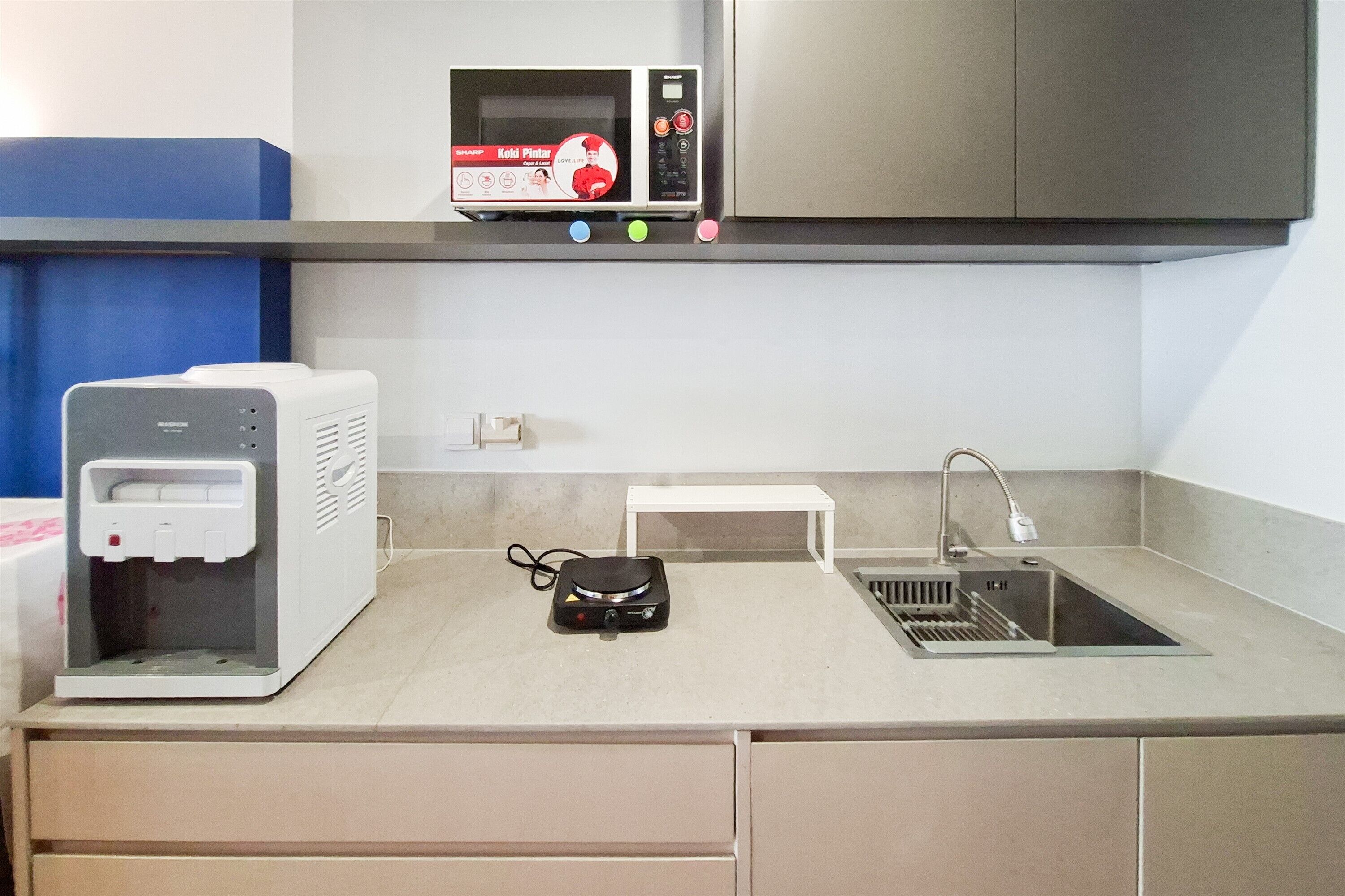 Una kitchenette con microondas, cafetera, pileta y una mesita.