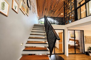 A modern interior with a staircase, wooden flooring, and a dining area. - Tropical 3BR Villa Coco Nusa Dua Bali (Nusa Dua)