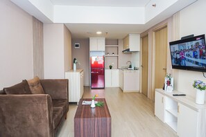 Ein modernes Wohnzimmer mit einem braunen Sofa, einem Holztisch und einem an der Wand befestigten Fernseher.