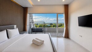 Een moderne hotelkamer met een groot bed, een balkon met uitzicht, een wandgemonteerde televisie en een schuifdeur.