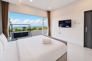 Habitación de hotel con una cama grande, un televisor en la pared y un balcón con vistas a la ciudad.