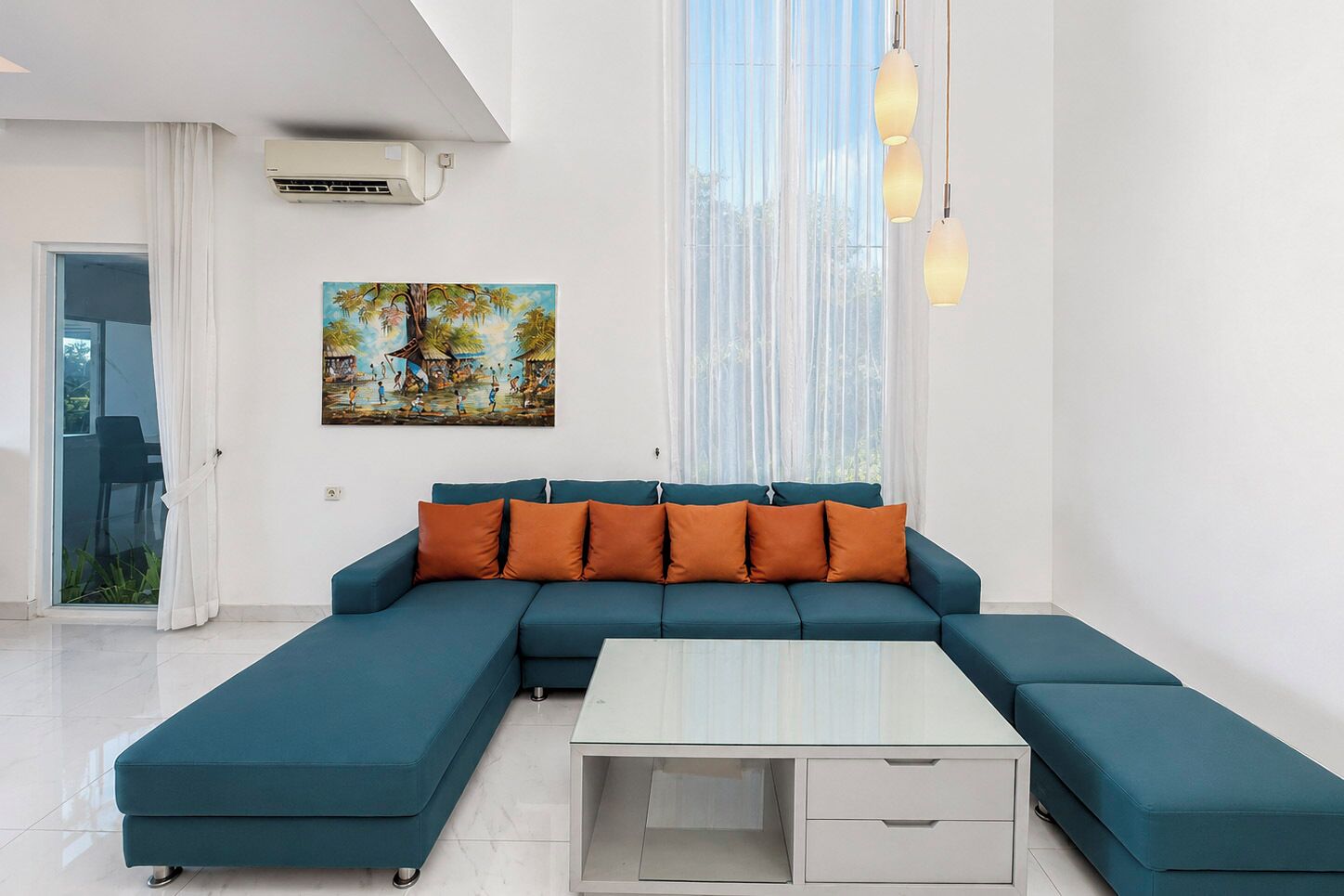 Ein modernes Wohnzimmer mit einem Ecksofa, einem Glastisch und einem Bild an der Wand.