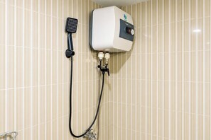 A wall-mounted shower unit with a handheld showerhead and a control panel. - Homey Simple Studio Room At Apartment Cinere Resort (Depok)