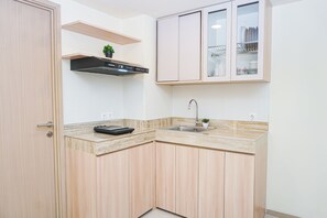 Cocina compacta con horno integrado, un lavamanos y una encimera con una balanza.