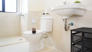 Een badkamer met een toilet, een wastafel en een douche.