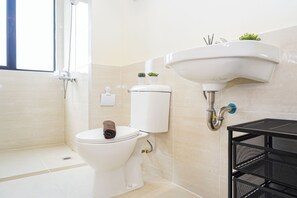 A bathroom with a toilet, a sink, and a shower. - Cozy And Functional 3Br At Apartment Meikarta (Cikarang)