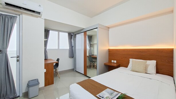 Ein Hotelzimmer mit Bett, Nachttisch und Schreibtisch mit Stuhl.