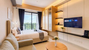 A modern hotel room with a bed, a sofa, a TV, and a balcony with a view. - Cozy Living Studio At Apartment Saffron Noble (Bogor)