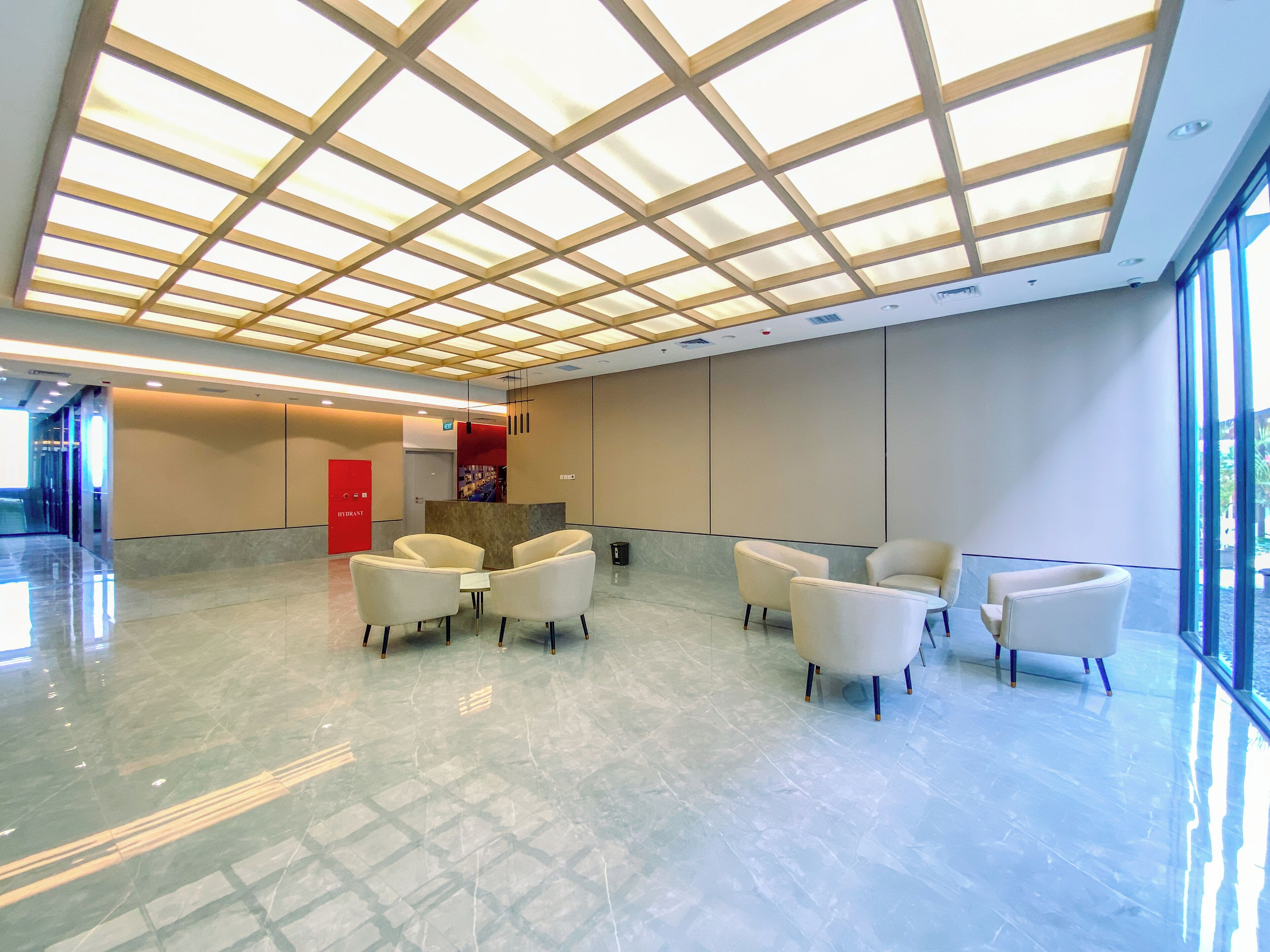 Um hall amplo com teto alto, balcão de recepção e área de estar.