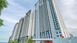 A high-rise residential building with multiple floors and balconies. - Cozy Living Studio At Apartment Saffron Noble (Bogor)