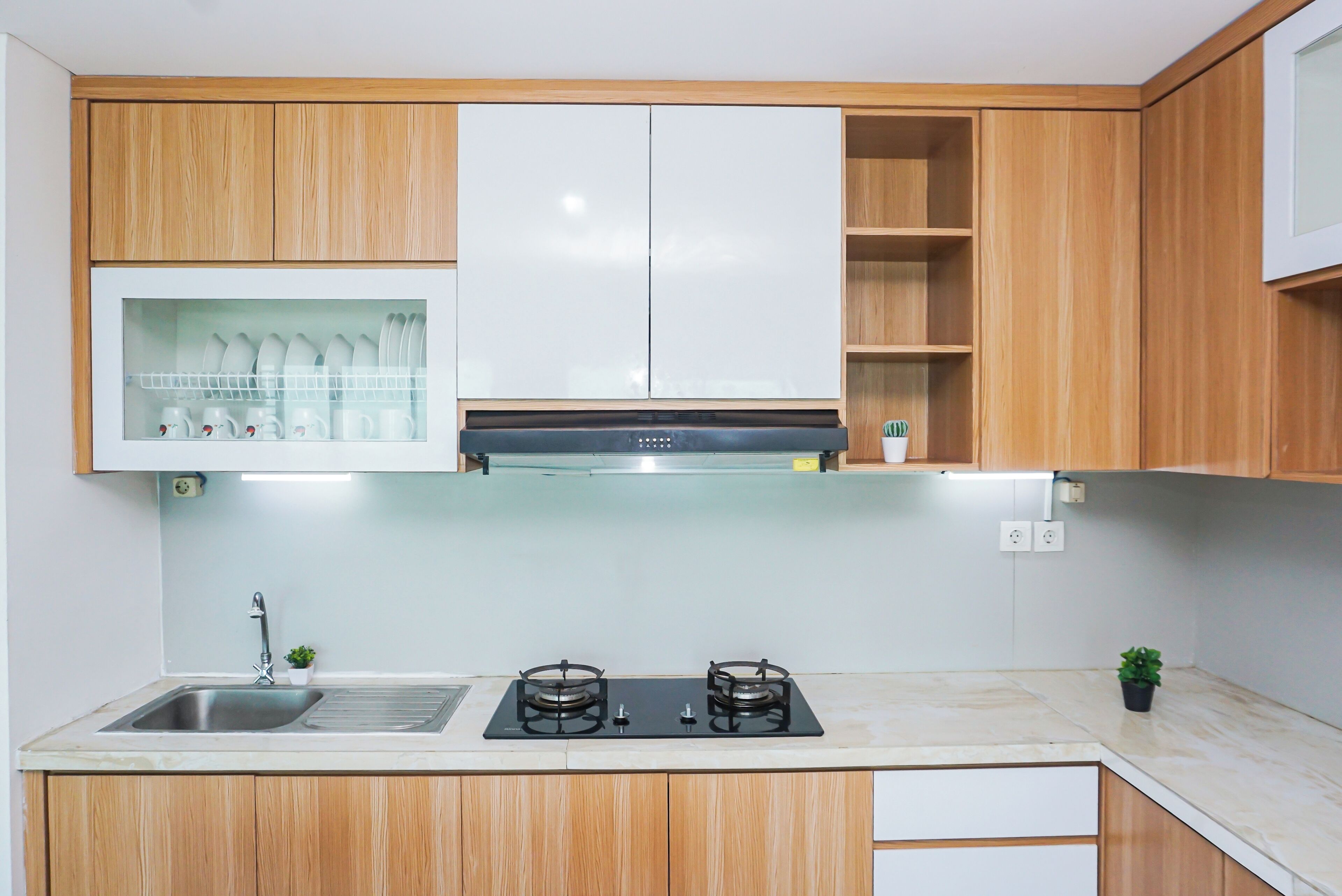 Una cocina moderna con armarios de madera, un lavamanos de acero inoxidable y una estufa a gas.
