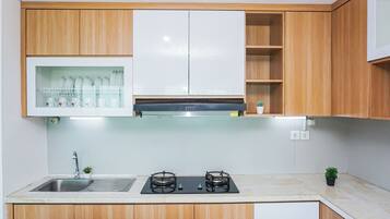 Una cocina moderna con armarios de madera, un lavamanos de acero inoxidable y una estufa a gas.