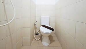 A small, tiled bathroom with a toilet, a shower, and a visible pipe. - Nice And Tidy 1Br At Apartment Urbantown Serpong (South Tangerang)