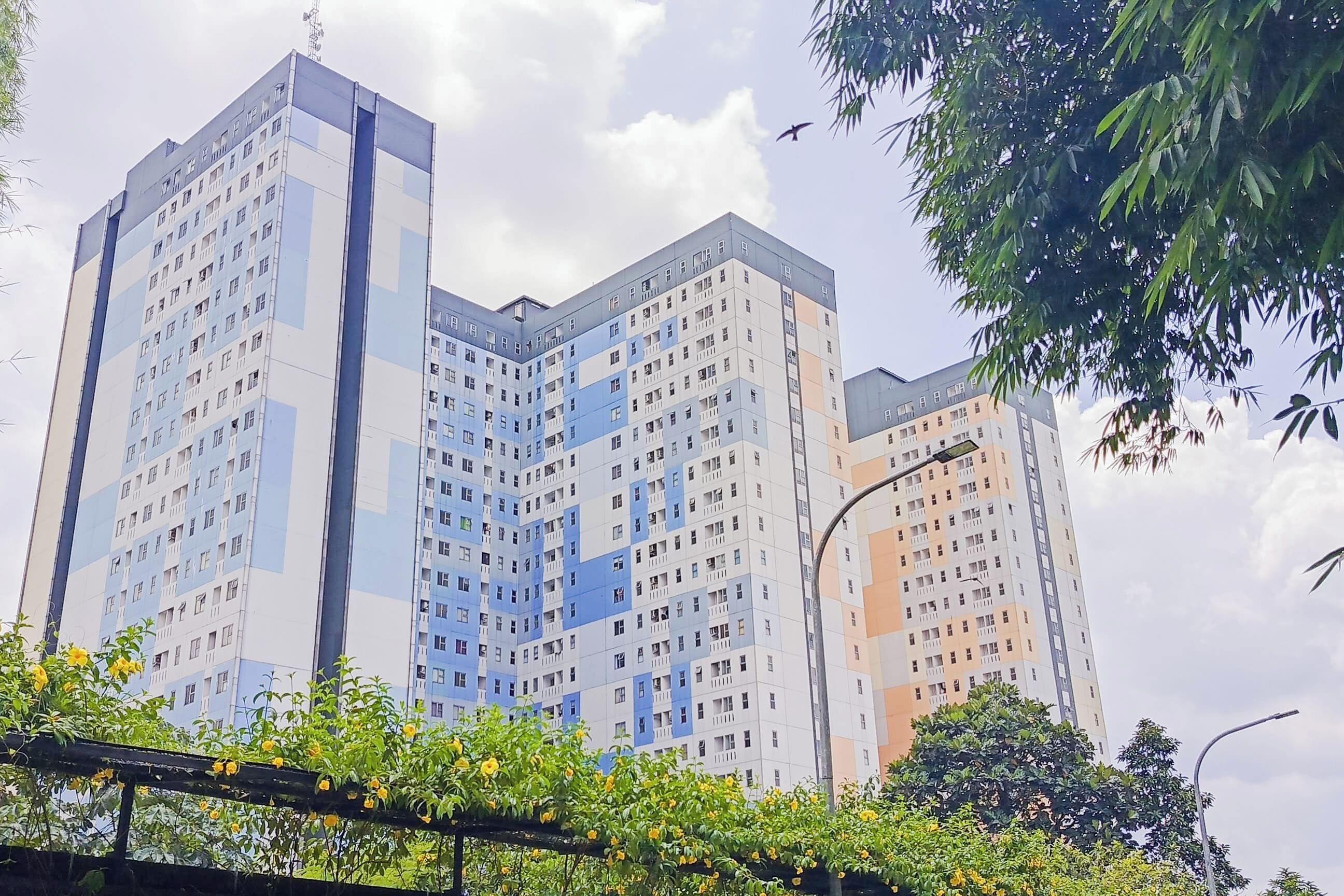 A multi-story residential building with a modern architectural design, featuring balconies and a uniform facade.